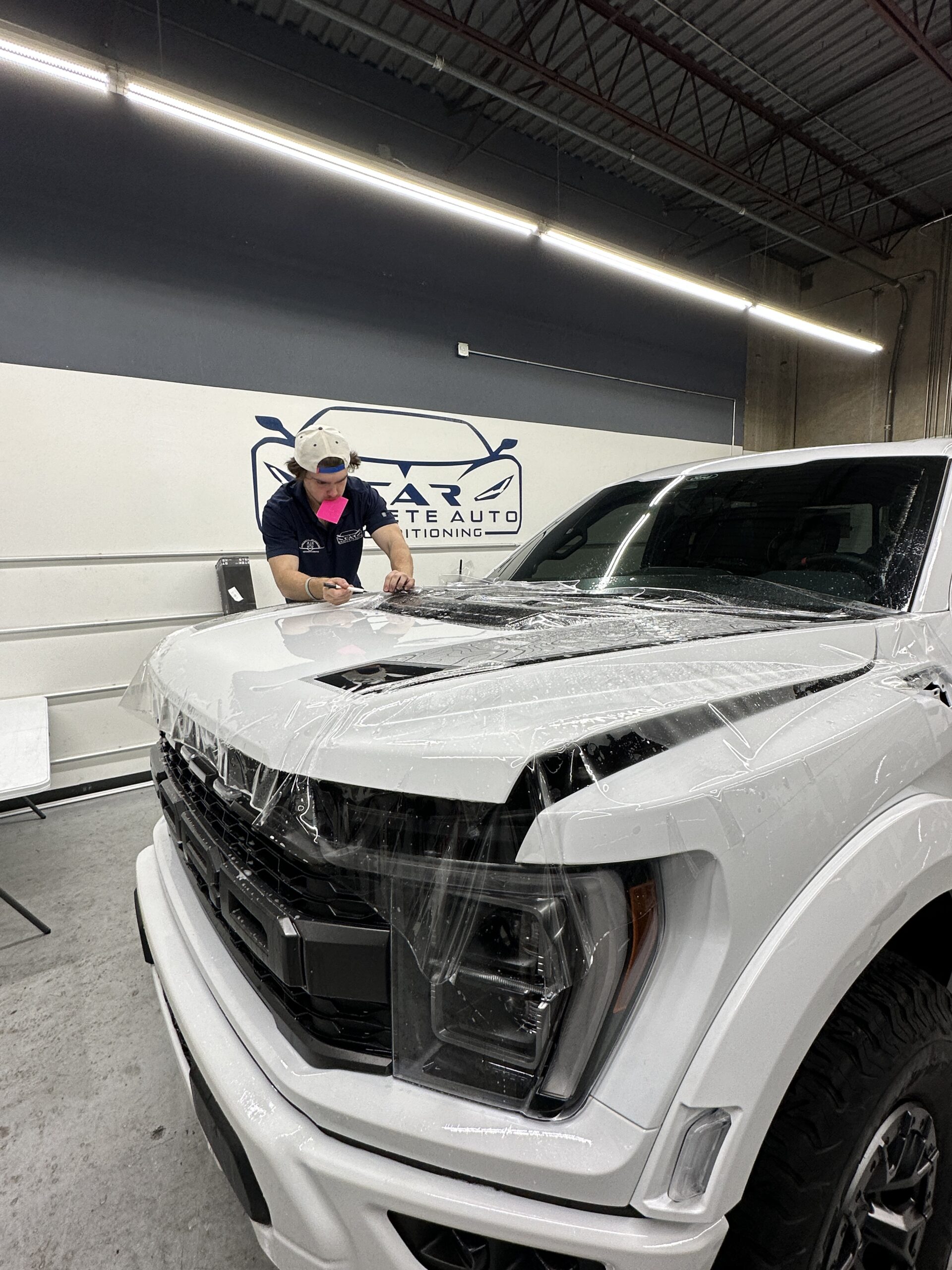 Paint protection film being installed on a truck hood at Car and Air